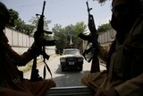 Taliban fighters hold their rifles while on patrol in the back of a ute