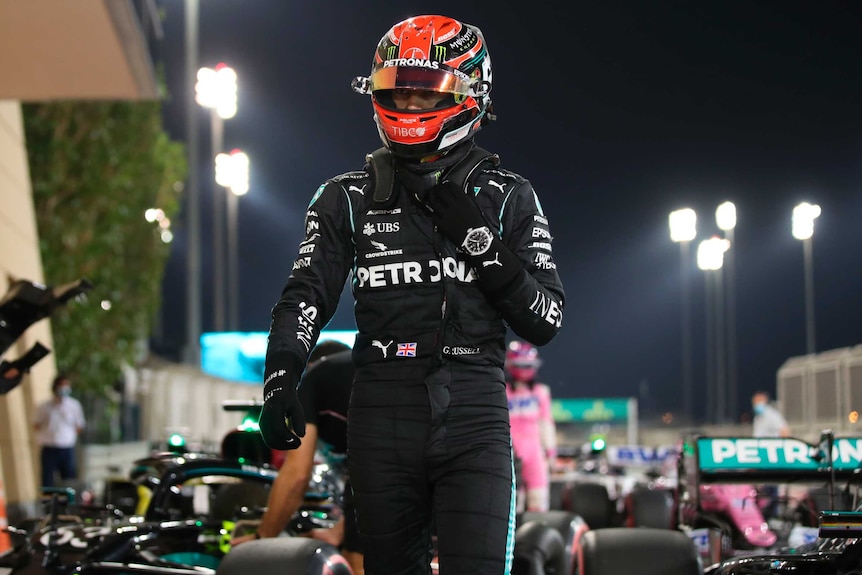 George Russell walks near the track while still wearing his helmet