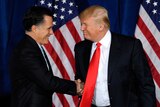 Mitt Romney shakes Donald Trump's hand.