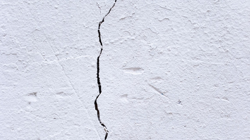 A large jagged crack in a white wall