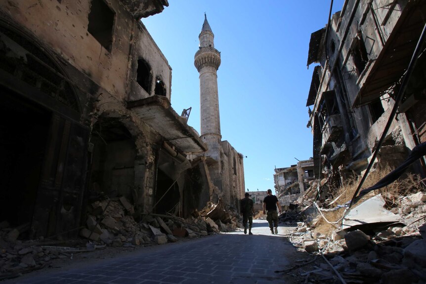 Syrian government soldiers walk in the damaged al-Farafira souk in the government-held side of Aleppo.