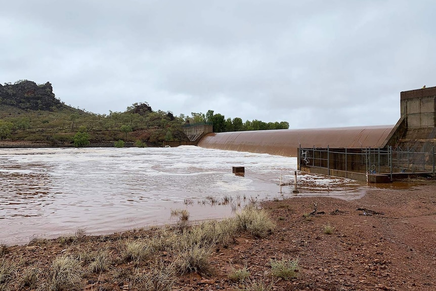 Floodwaters flow over spillway at Cloncurry Dam, east of Mount Isa in north-west Queensland
