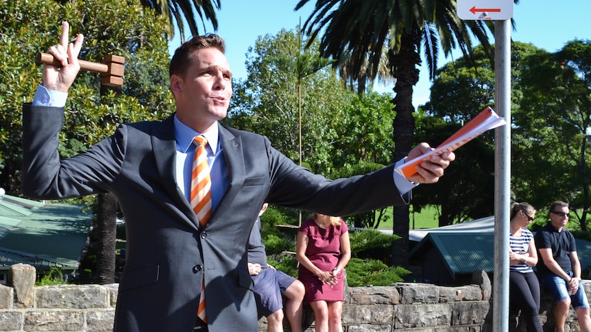 Toby Llewellyn, a 29 year old auctioneer with Cooley Auctions in Sydney, about to close a sale in front of a house for auction