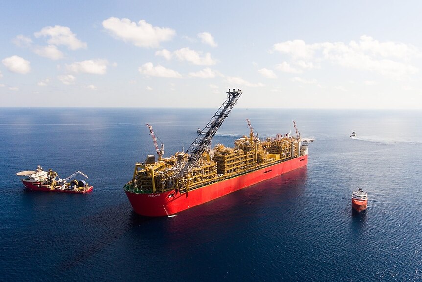 A gigantic floating gas platform, which looks like a bulk carrier, on a calm-looking sea.