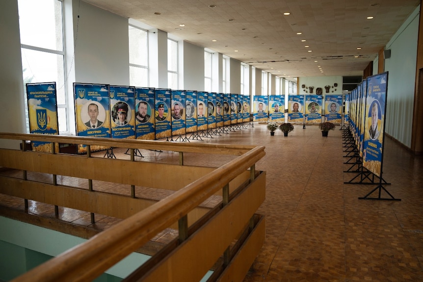 A large room with rows of pictures of men in it.