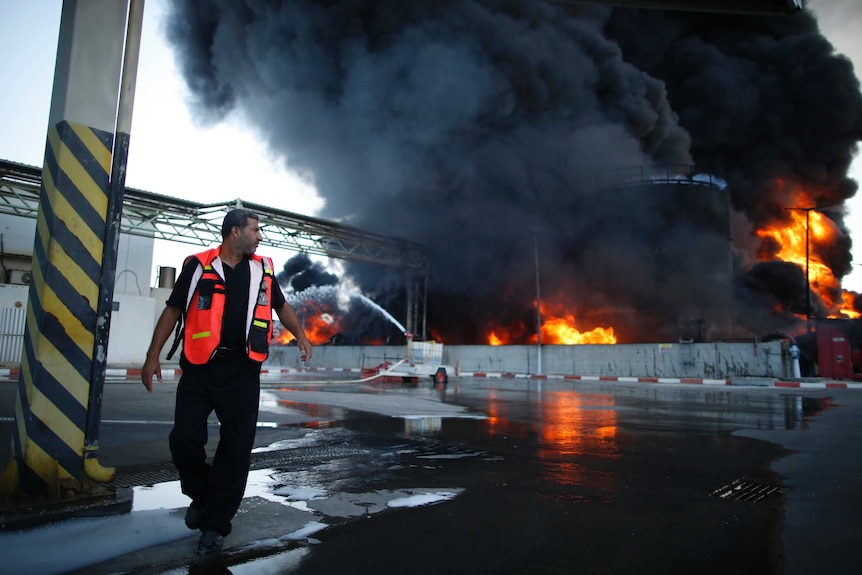 A Palestinian firefighter attends the fire at Gaza's power plant