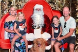 Burleigh Heads mother Emma Laing posing with her family at their annual Santa photo