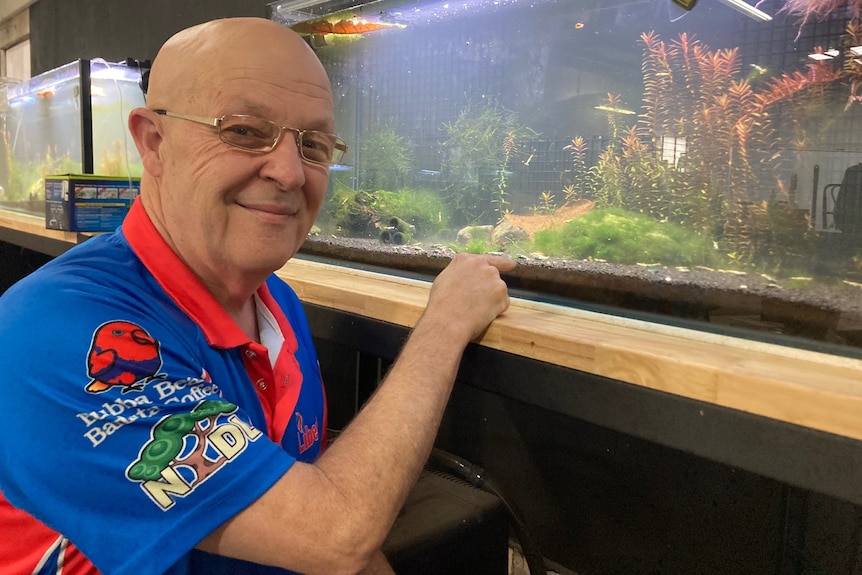 Man standing in front of a fish tank 