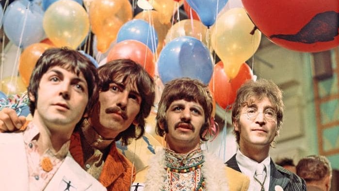 Los Beatles posan frente a unos globos de colores en la época del álbum de Sgt Pepper.