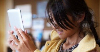 A young girl uses an iPad.