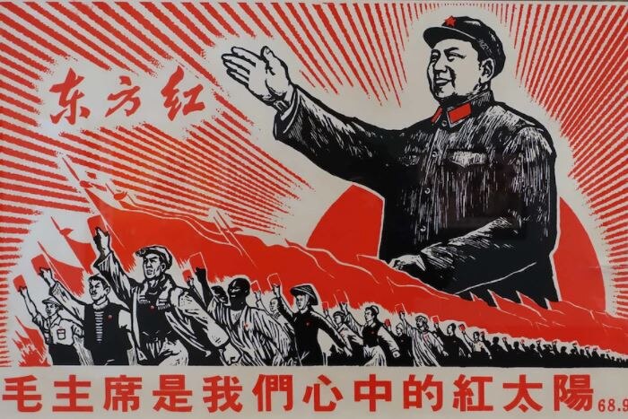 A Chinese propaganda poster with Mao Zedong overlooking Chinese workers.
