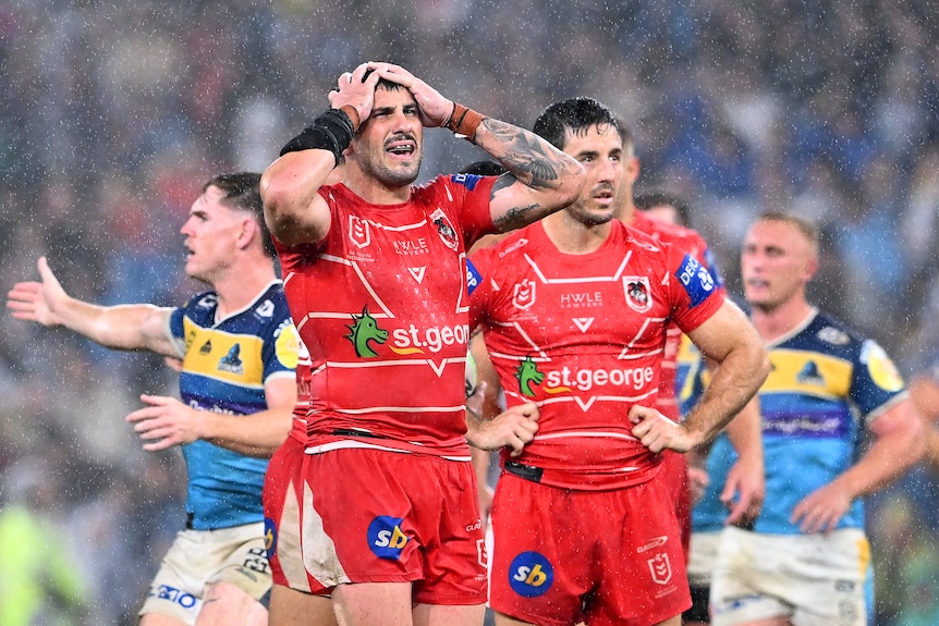 Jack Bird puts his hands on his head and looks pained as St George Illawarra teammate Ben Hunt stands with him in the rain.