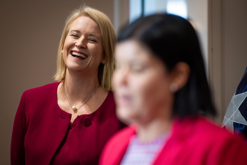 Nicole Manison laughs during a press conference with Natasha Fyles in the foreground.