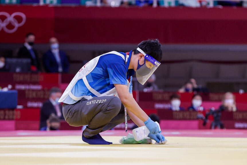 A cleaner disinfects a surface at the Tokyo Olympics.
