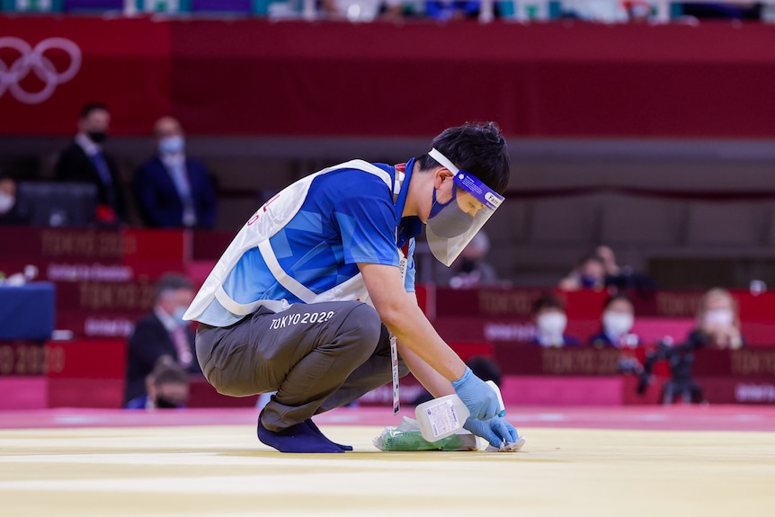 A cleaner disinfects a surface at the Tokyo Olympics.