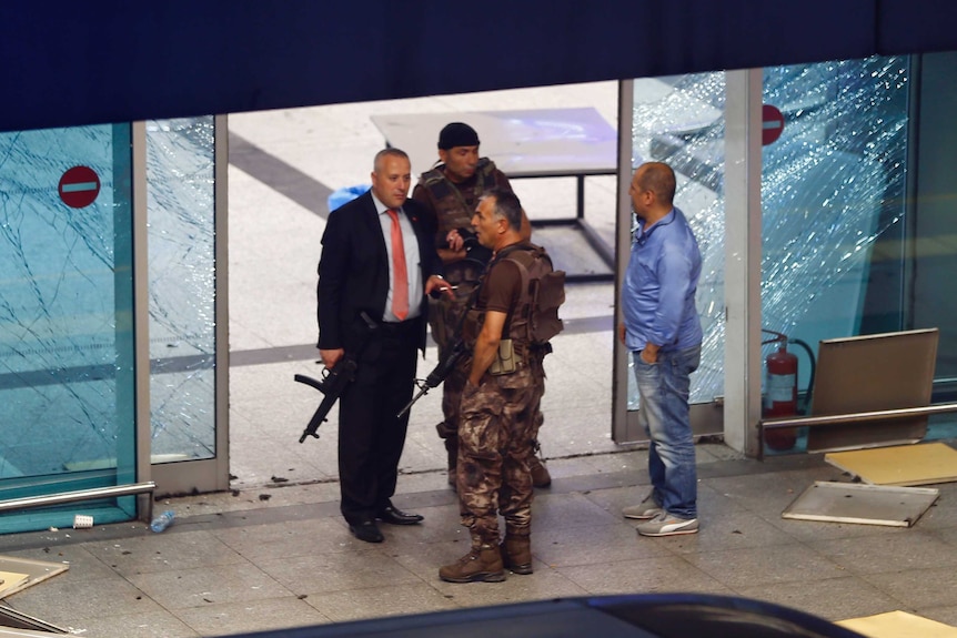 Armed security stand at an entrance of Turkey's largest airport, Istanbul Ataturk, after the explosions.
