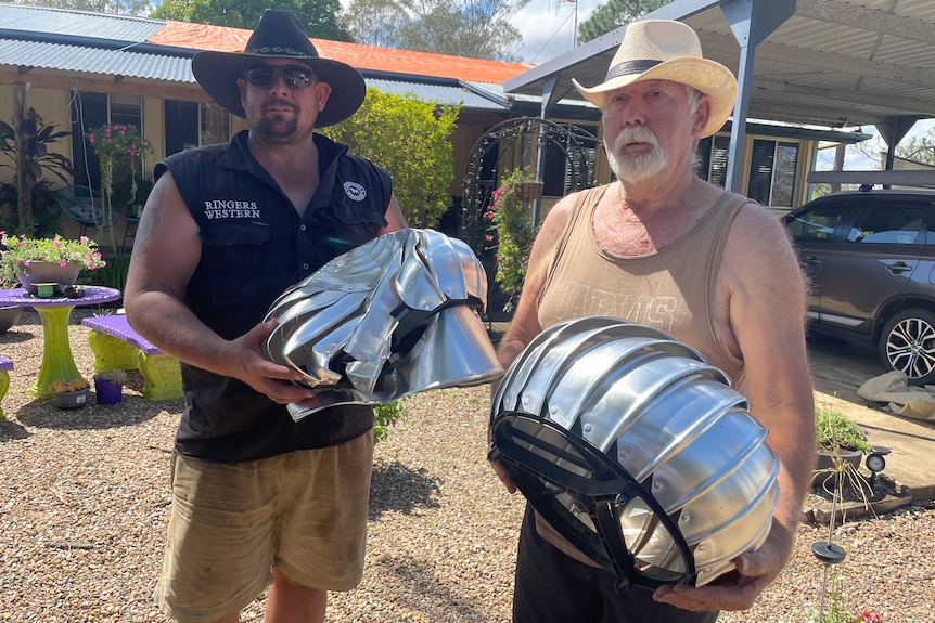 Two men in cowboy hats holding damaged whirlybirds