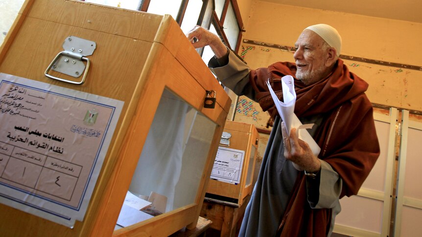 Old Egyptian man places ballot in box