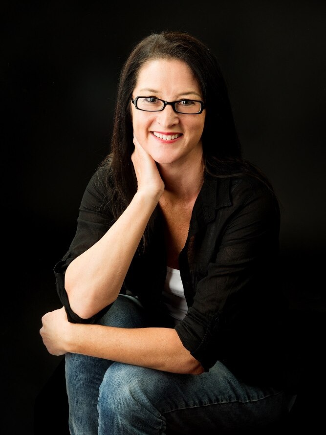 Author Fleur Ferris - long dark hair, glasses, smiling.