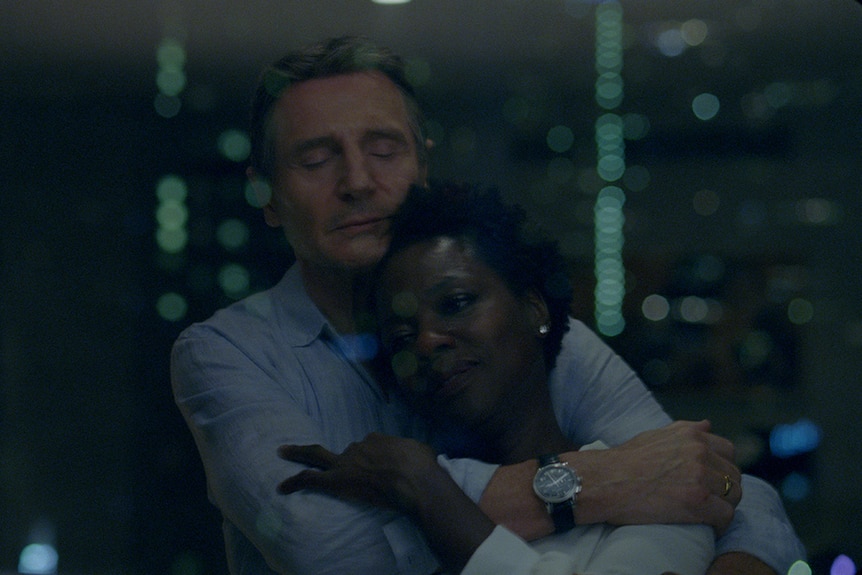 Colour still of Liam Neeson embracing Viola Davis in 2018 film Widows.