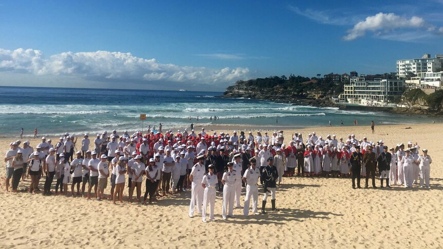 Hundreds of people on Bondi Beach in the shape of Australia.