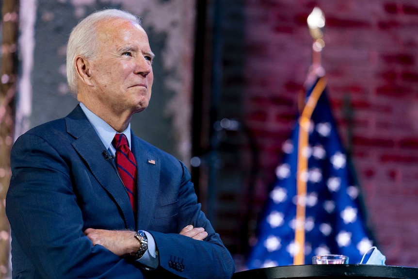 Democratic presidential candidate former Vice President Joe Biden folds his arms.