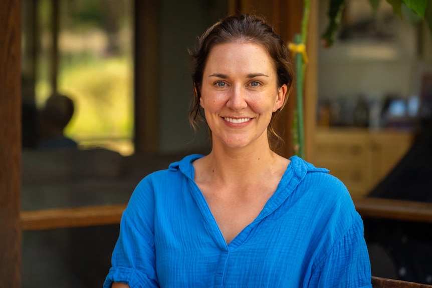 A portrait shot of Alison Jones wearing a bright blue top with the background out of focus