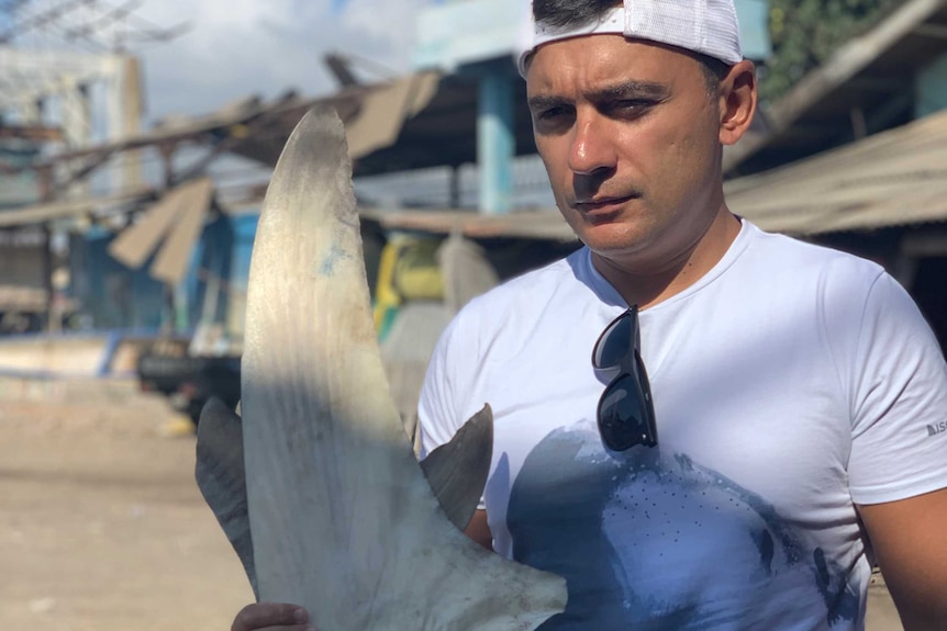 a man shows off a shark fin