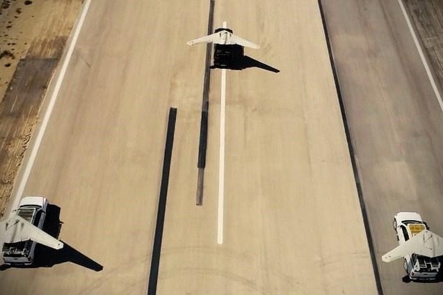 Three drones on the backs of utes are shown on an Iranian runway.