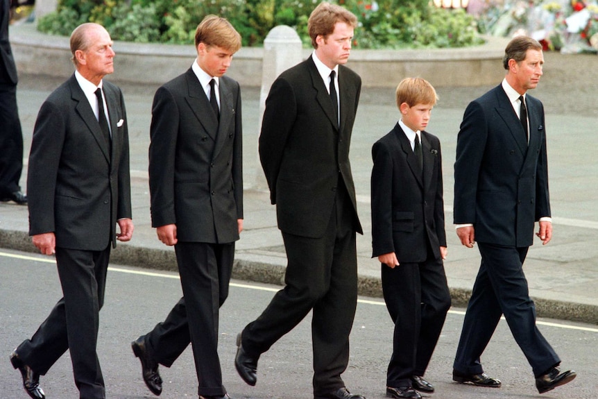 Prince Philip walks with a young Prince William and Harry behind their mother Diana's coffin.