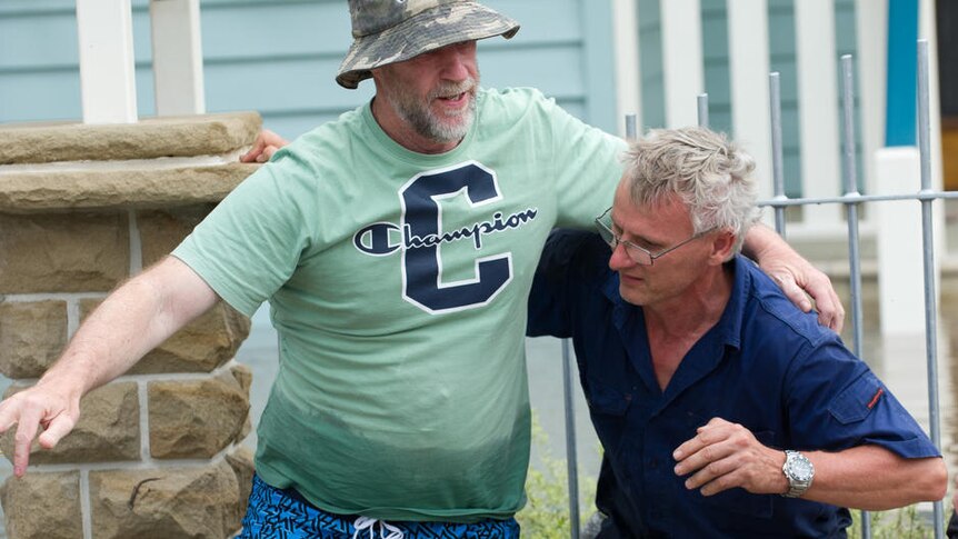 Two men in the flood-hit Brisbane suburb of Yeronga evacuate their property on January 12, 2011.