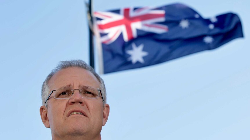 Prime Minister Scott Morrison's head with an Australian flag flying in the background