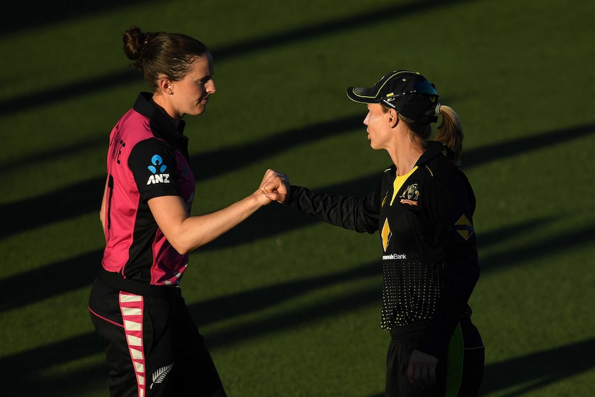 A New Zealand cricketer and the Australian captain bump fists after a women's T20 international.