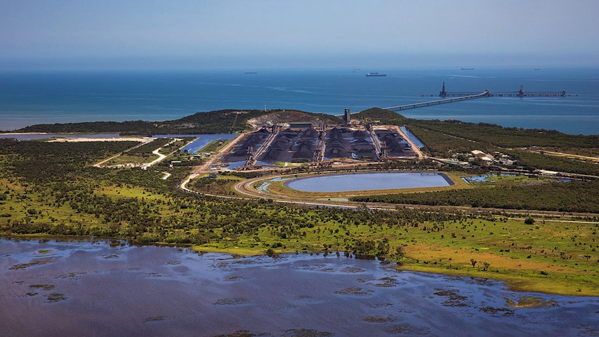 A coal storage area and dam beside a coastal wetland