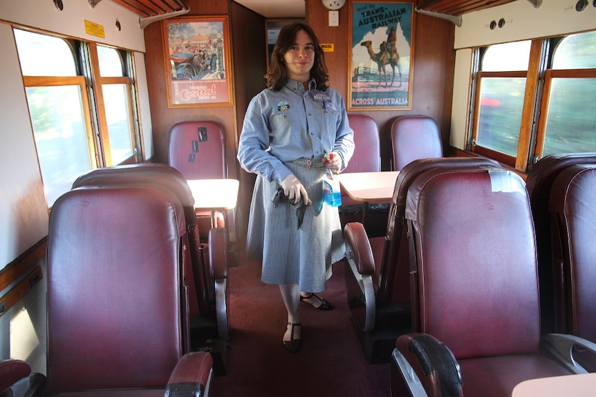 A woman cleaning surfaces on a steam train