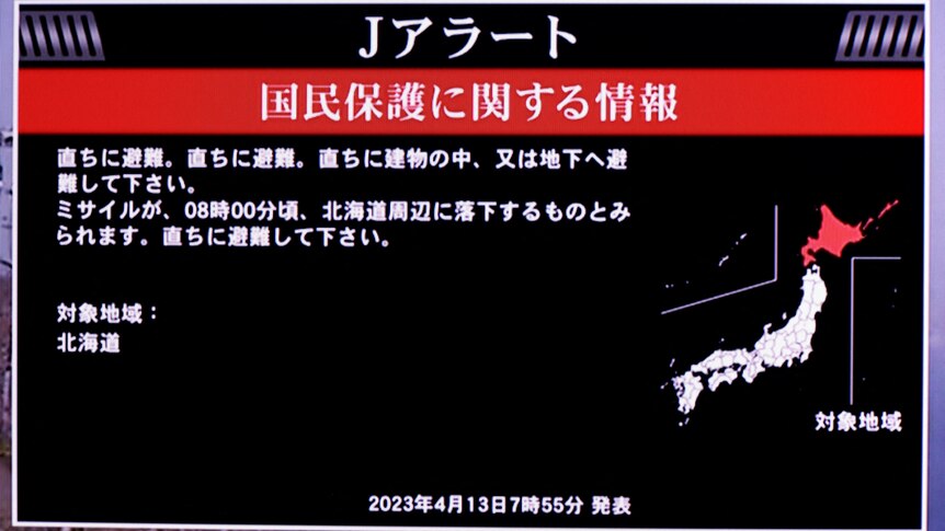 A TV screen displays a warning message called "J-alert" after the Japanese government issued a missile alert.