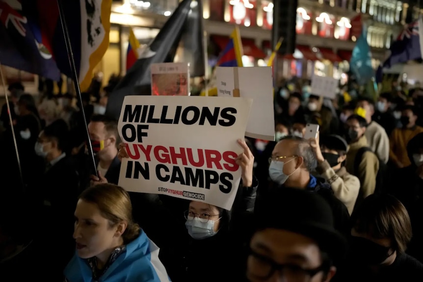 A crowd of protesters holding up large signs 