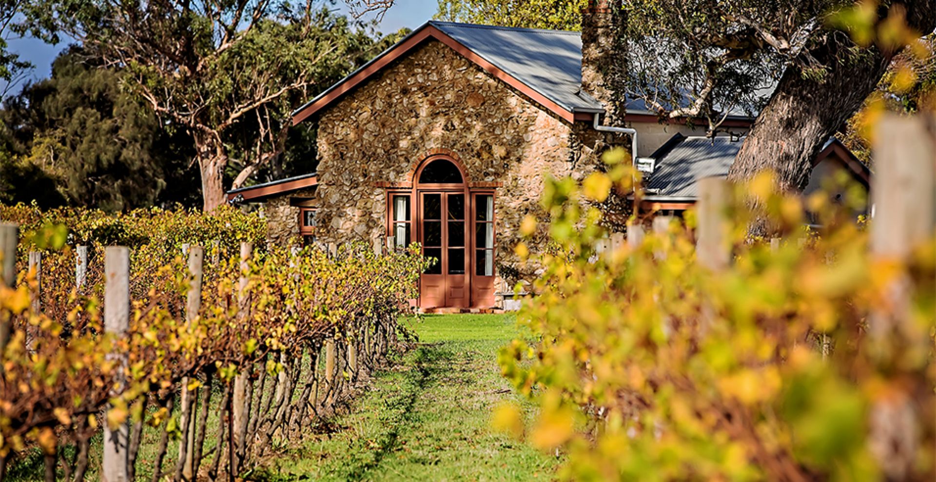 An old stone building with a vineyard. 