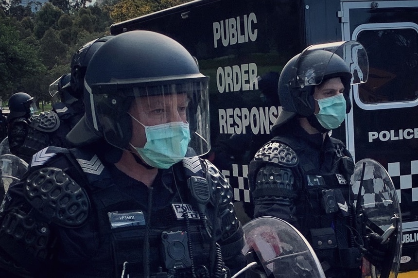 Police wearing face masks and riot shields outside the Shrine of Remembrance.