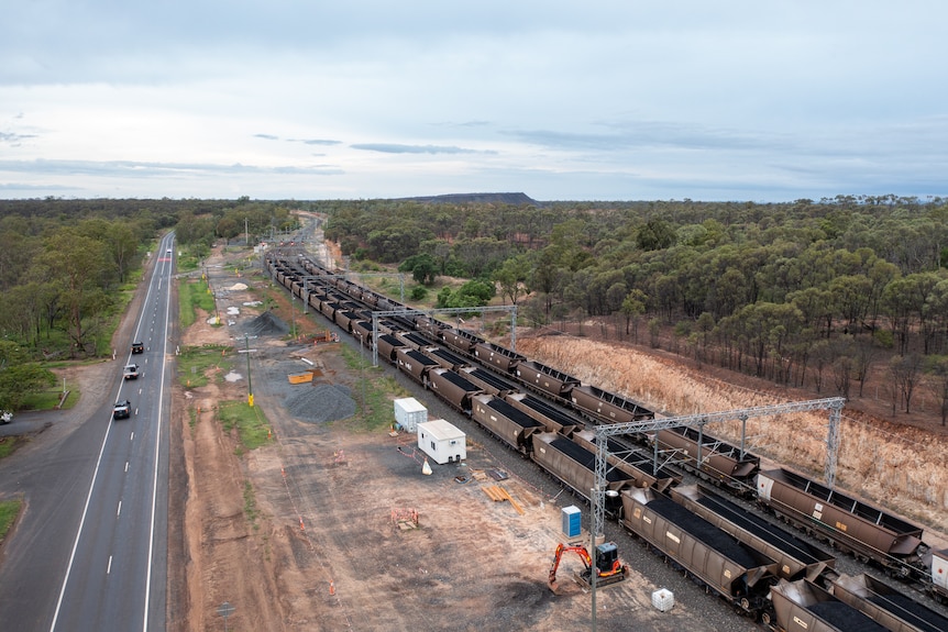 Arial photo of a line of coal trains parallel to the highway near Bluff, Queensland, November 2021.