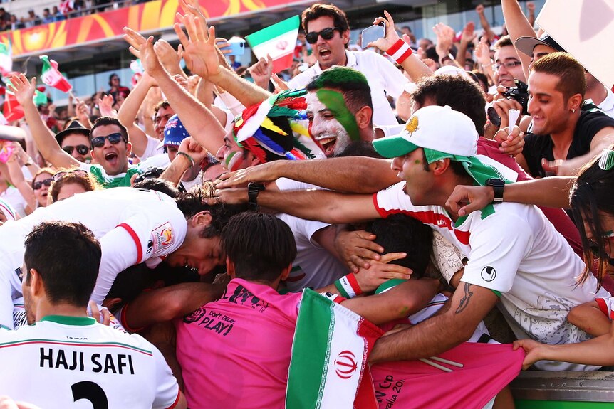 Iran player Sardar Azmoun celebrates with team mates and fans after scoring a goal in the Asian Cup quarter final.