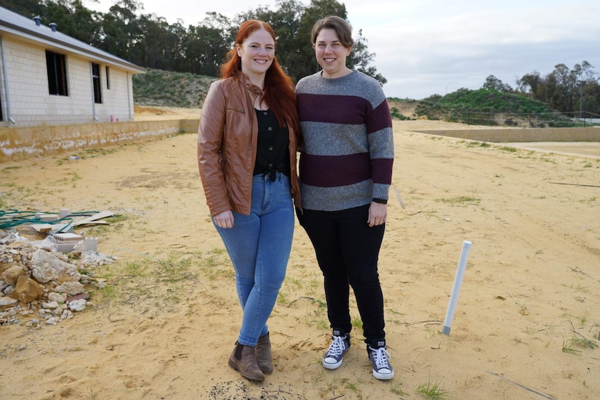 Two women standing in front of block of land