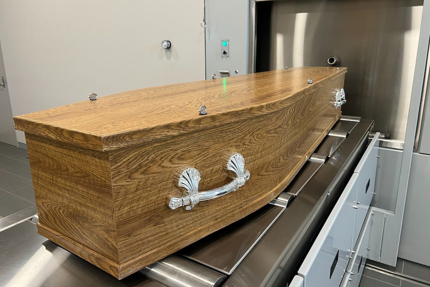 a coffin entering a cremator