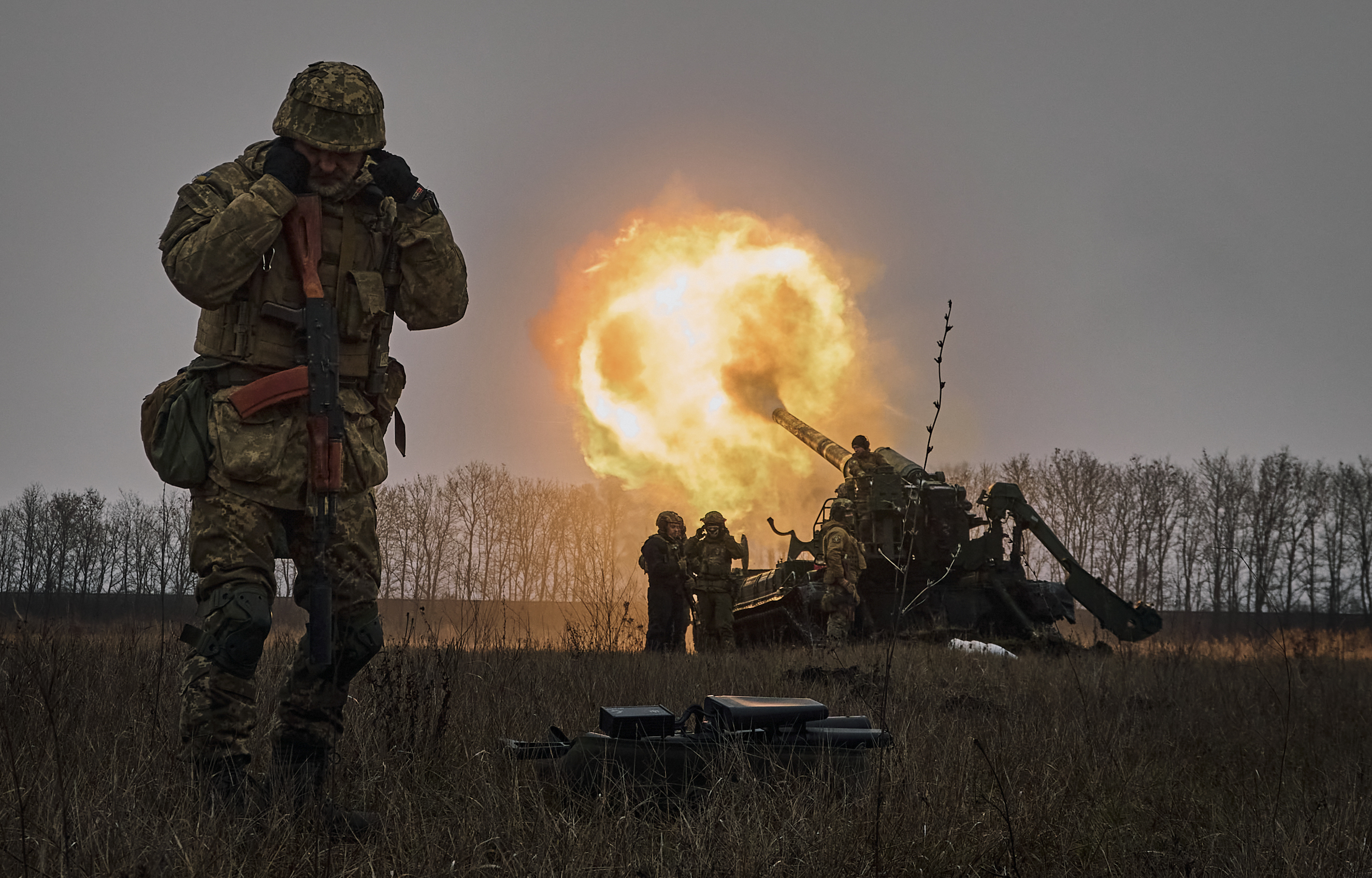 当其他人向俄罗斯阵地发射 Pion 火炮系统时，一名乌克兰士兵捂住了耳朵。