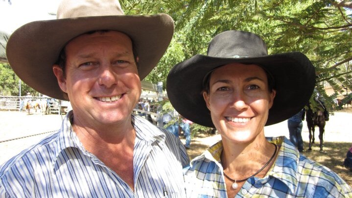 A man and woman smile at the camera