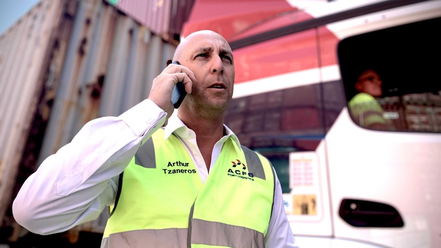 Truck owner Arthur Tzaneros stands in front of one of his vehicles loaded with containers at Port Botany.