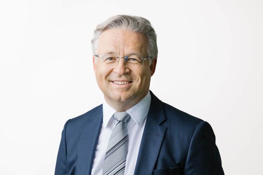 A corporate profile shot of Andreas Schwer wearing a suit and tie on a white background