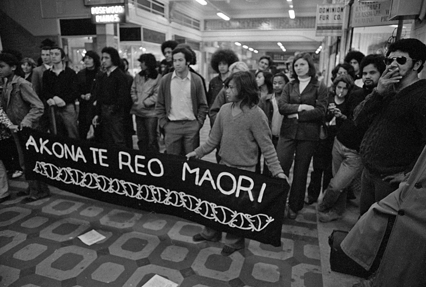 A black and white image shows a banned that says 'akona te reo Maori'