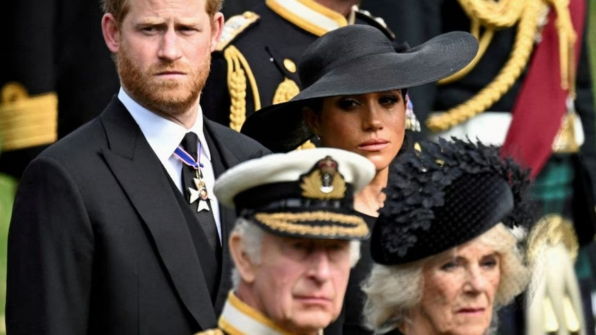 Meghan Markle cries as she stands next to Prince Harry, behind Queen Camilla and King Charles