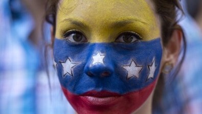A young woman with the Venezuelan flag painted onto her face